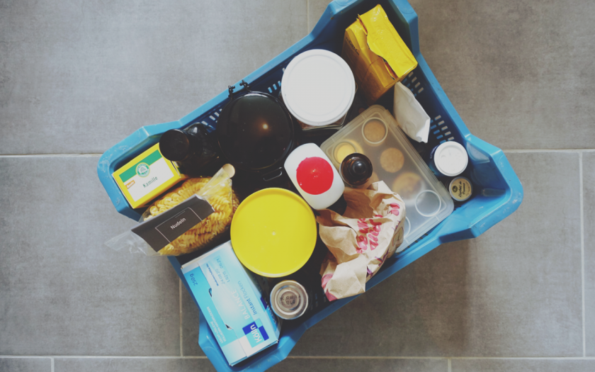 Beitragsbild // Lowwaste im Urlaub // Das Bild zeigt eine gepackte Kiste mit Lebensmitteln, verpackt und teilweise auch OVP mit und ohne Plastikpackungen.